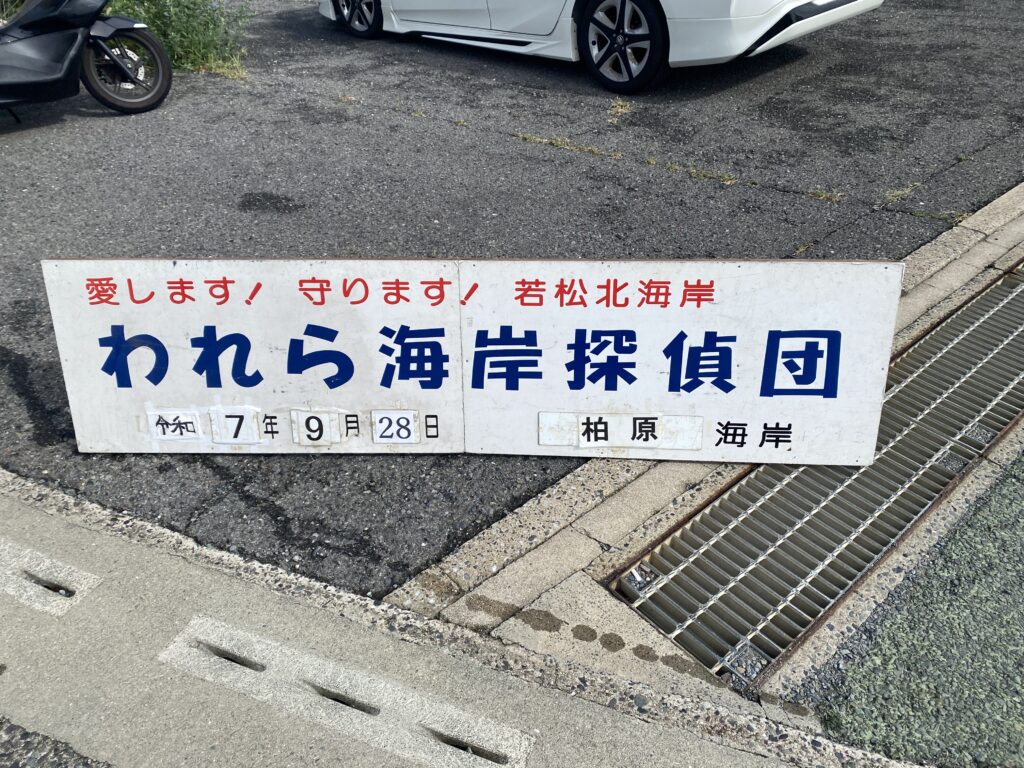 われら海岸探偵団の柏原海岸での海岸清掃活動日を記載した看板