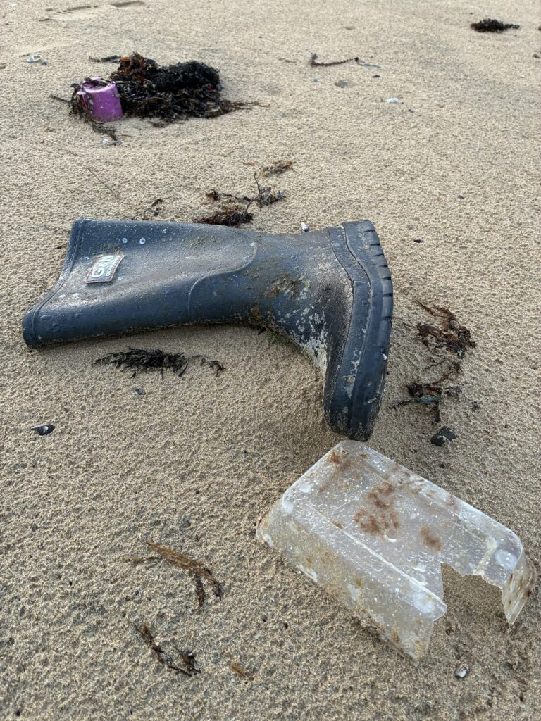 海岸に打ち上げられた長靴とプラスチックトレー